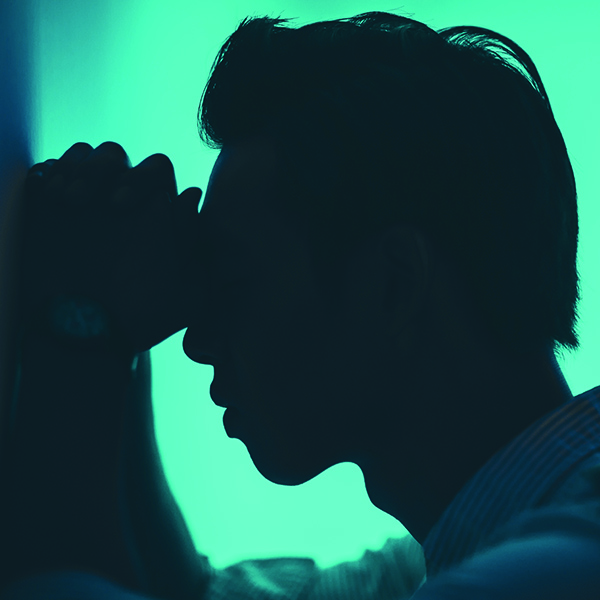 Silhouette of asian man frustrated with hands on his head